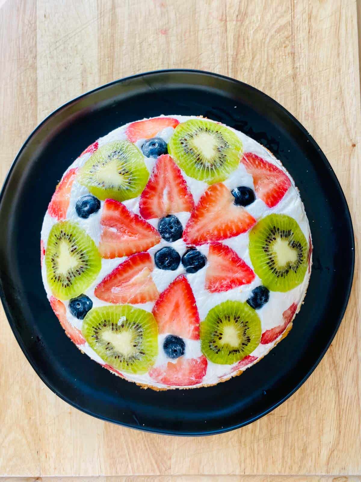 overhead view of fruit dome cake on a black plate