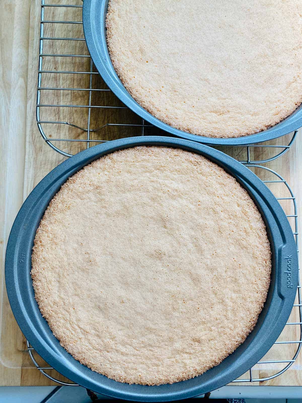 sponge cakes in baking pans cooling on wire racks