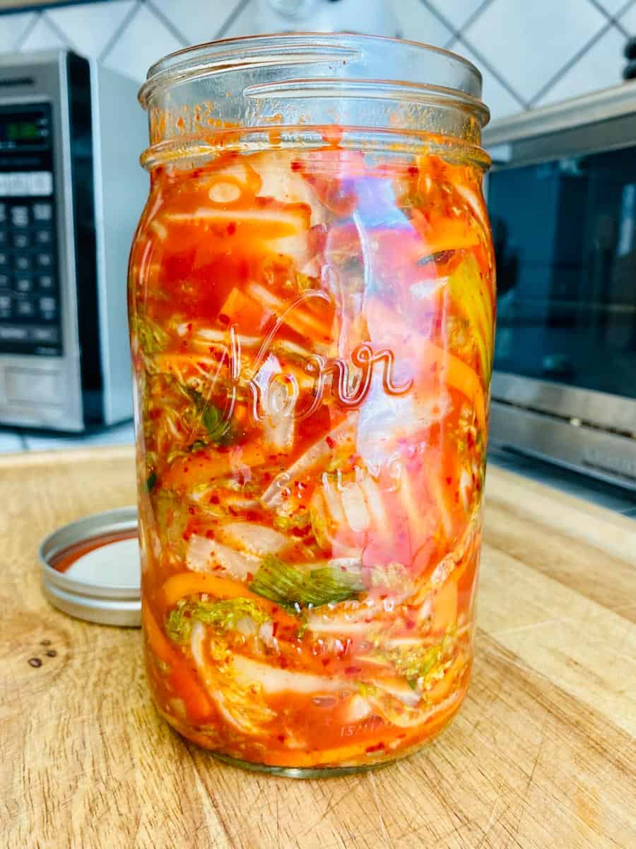 Open mason jar of prepared kimchi in all it's pungent glory