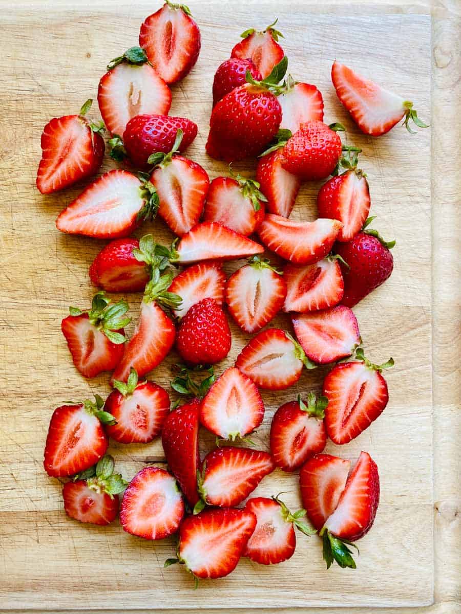 Strawberries with tops on, cut in half lengthwise