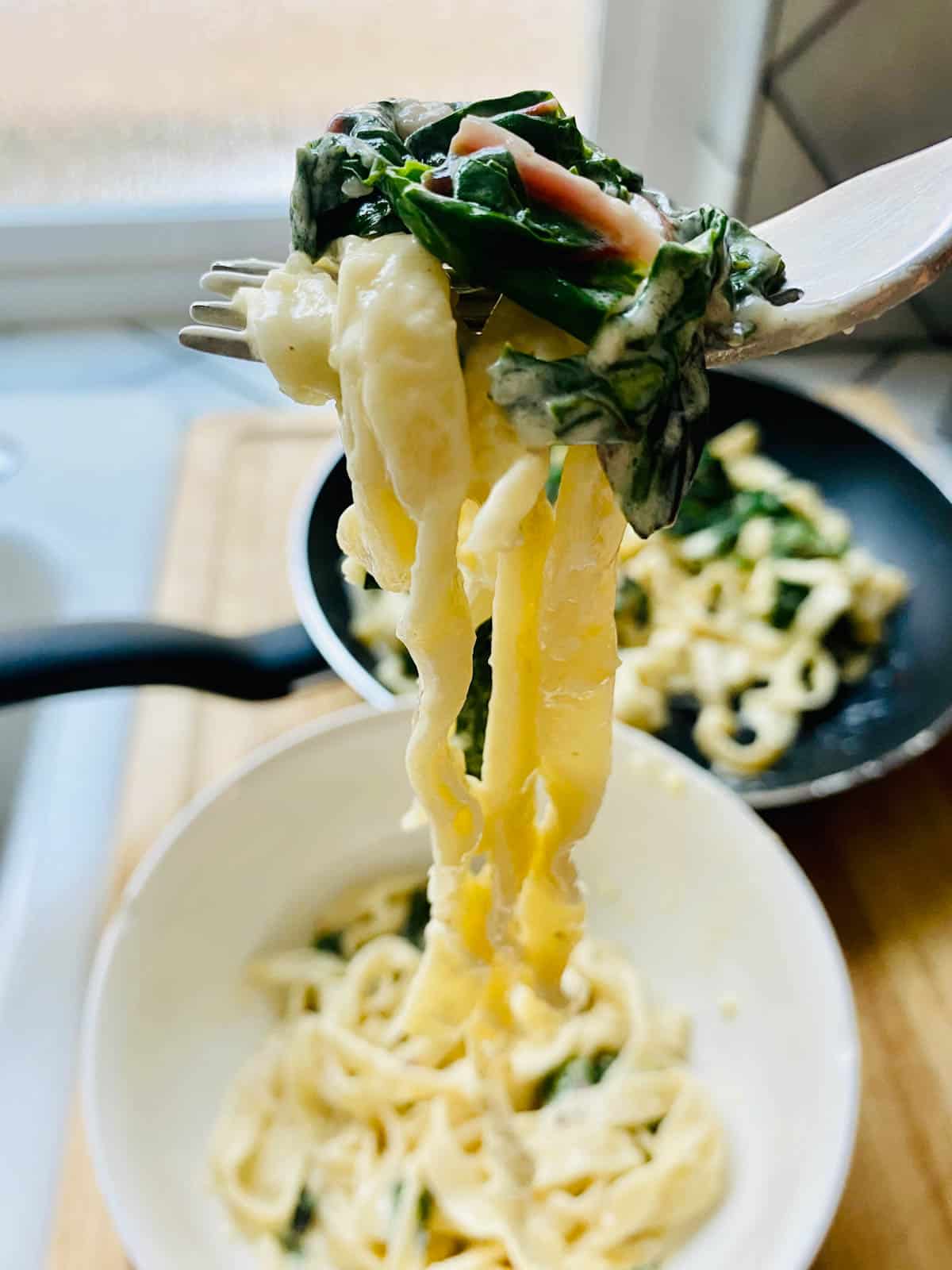 Forkful of pasta with preserved lemon Alfredo and Swiss chard. It's heavenly!