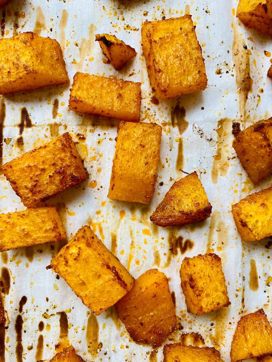 Cubes of roasted pumpkin on parchment paper.