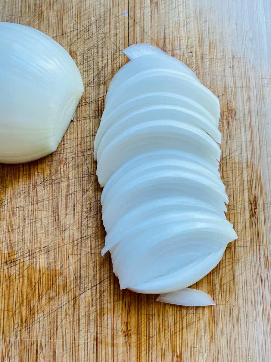 Sliced onions on a wooden cutting board. Don't cry.