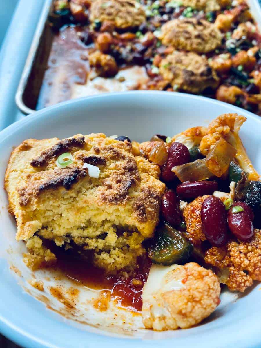 A bowl of veggie chili with cornbread biscuit.