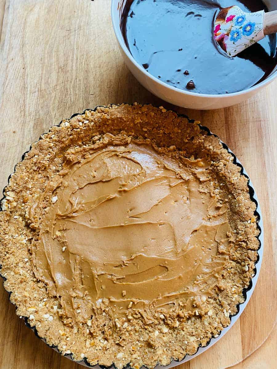 Prepped crust spread with peanut butter and awaiting chocolate ganache.