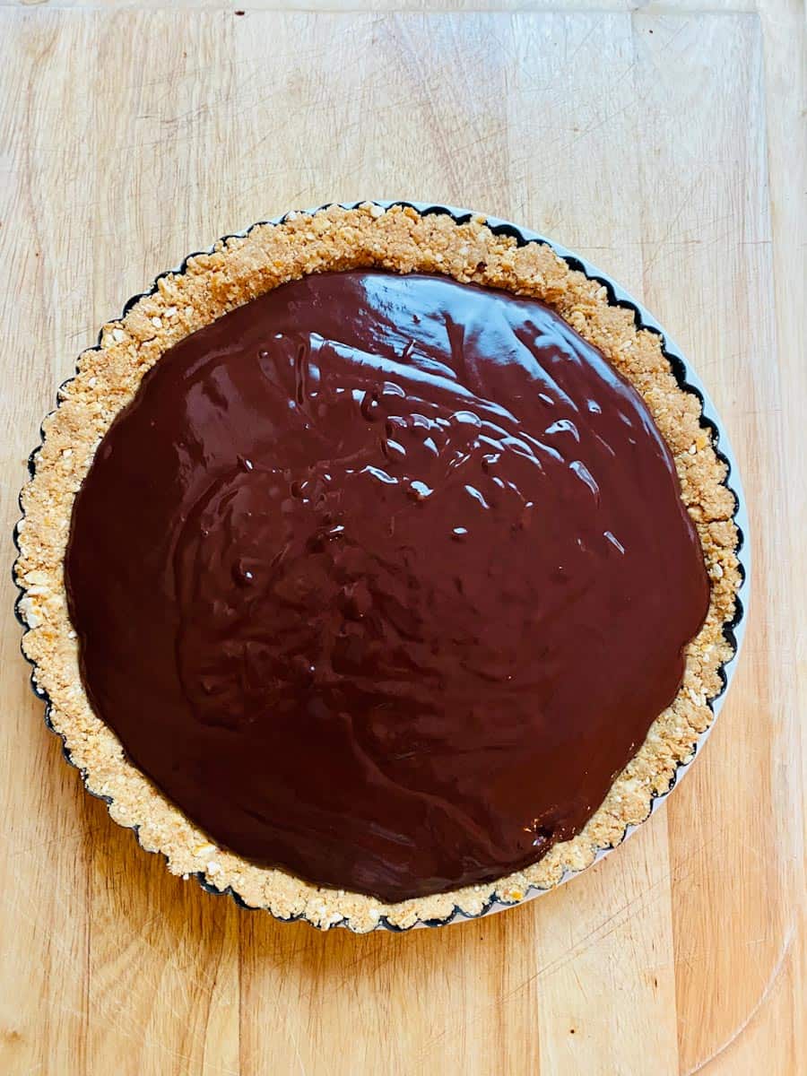 Chocolate ganache filled pie looking smooth and glossy.