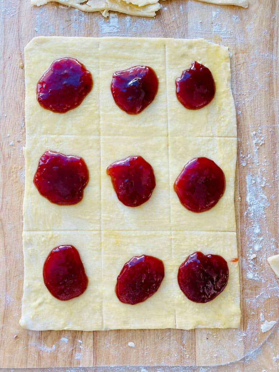 Pastry dough with mounds of strawberry jam.