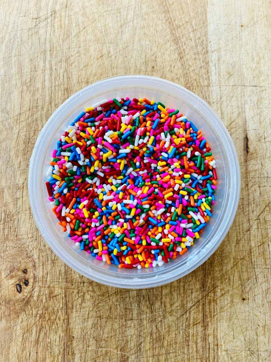A container of rainbow colored sprinkles.