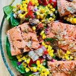 Grilled salmon atop bed of spinach, corn, tomato salad