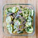 Marinated zucchini and yellow squash in a square glass dish