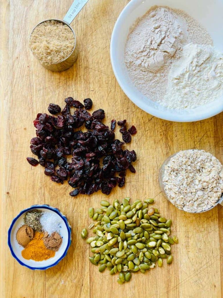Two types of flour, oats, pepitas, spices, dried cranberries, and brown sugar.