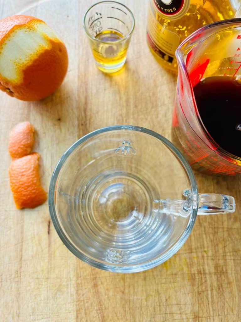 Ingredients include Licor 43, hot coffee, and orange peel.