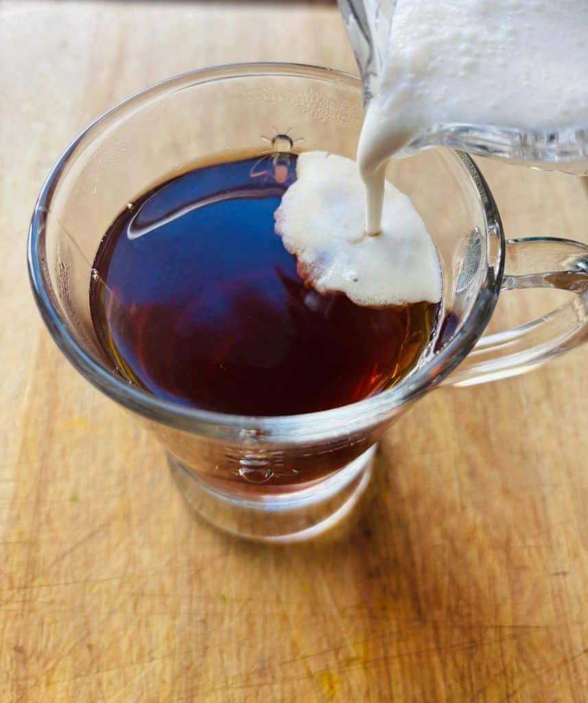 Frothy milk poured into tea.