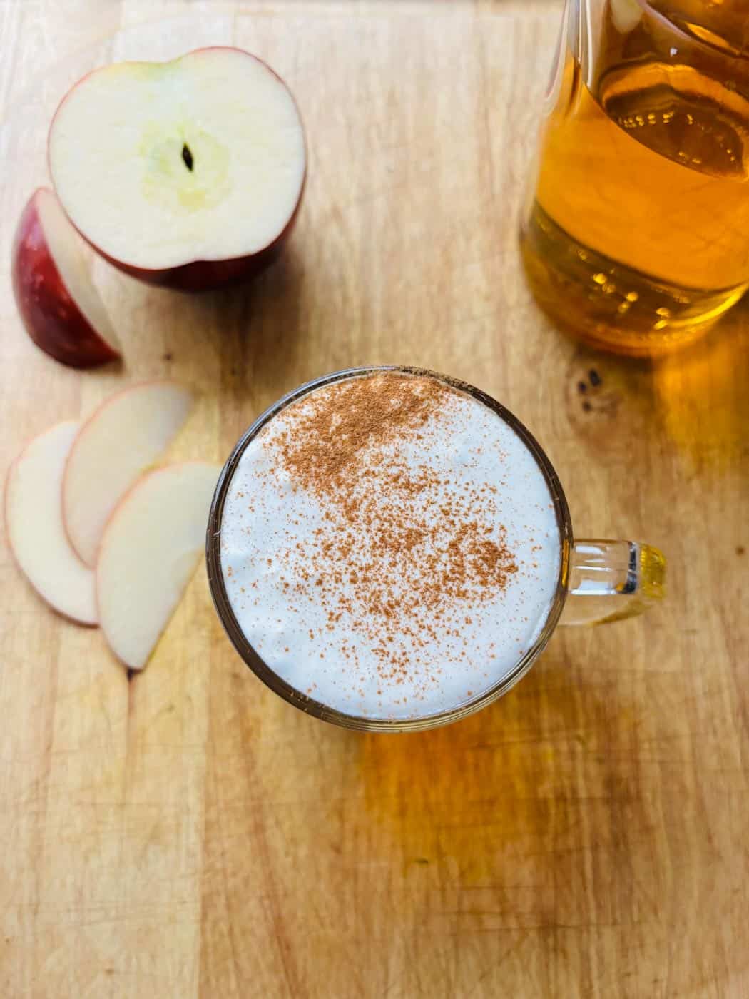 Overhead drone view of the drink, plus sliced apples, and a bottle of Licor 43.