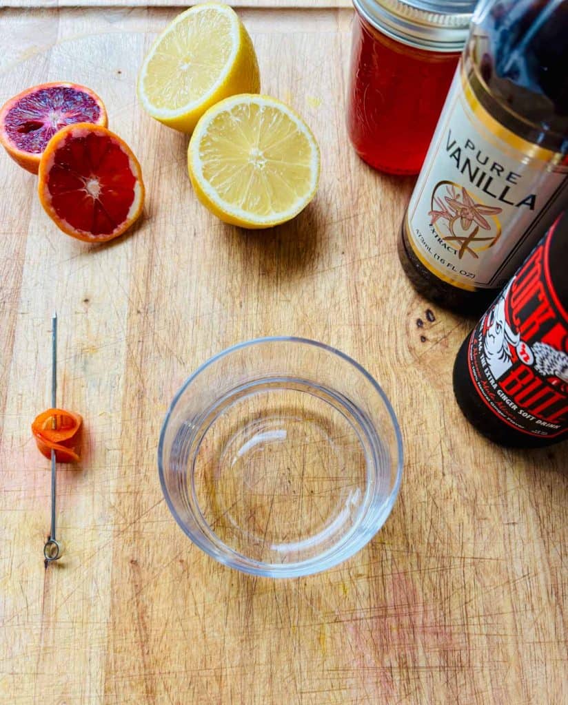 Blood orange, lemon, blood orange simple syrup, vanilla, ginger beer, and rocks glass.