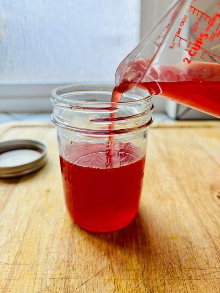 Pouring the liquid elixir into a mason jar!
