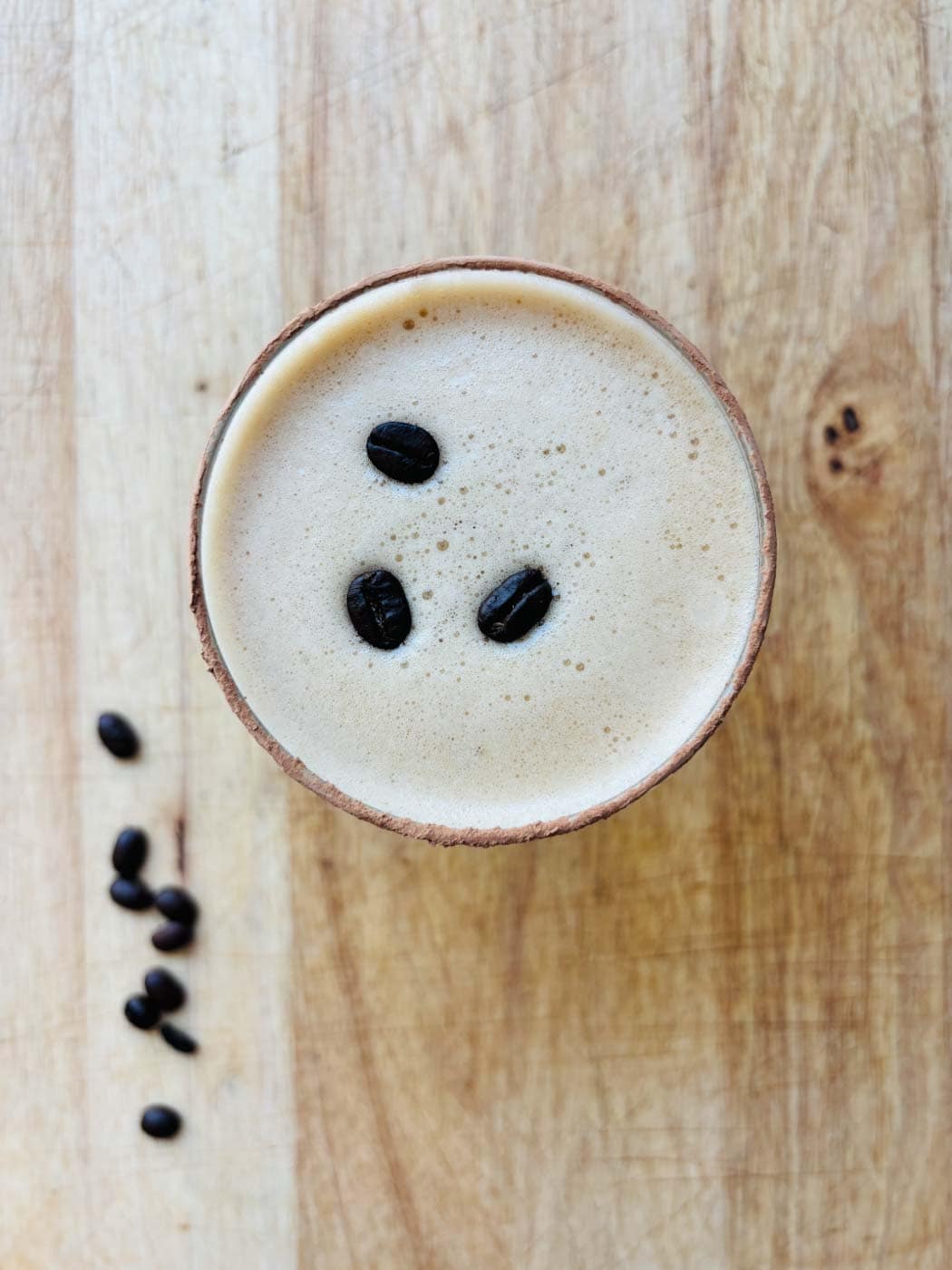 Drone view of espresso Martini mocktail garnished with three coffee beans.