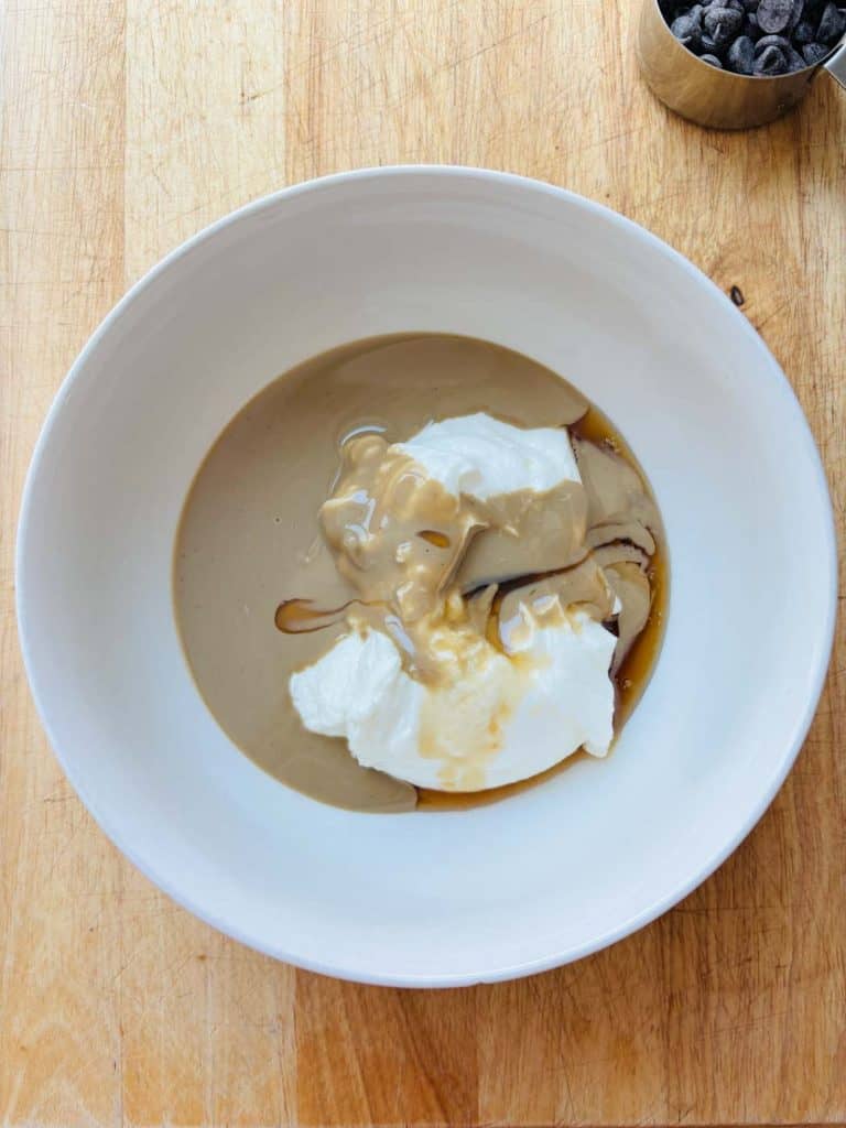 Yogurt, tahini, and maple syrup in a mixing bowl.
