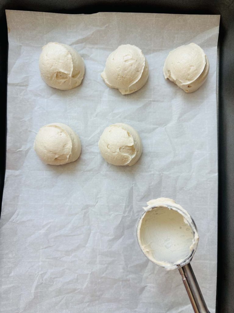 Scooping the yogurt mixture onto a parchment lined sheet.