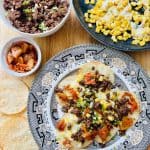 Korean Nachos assembled with crispy chips, kimchi, ground beef, and cheesy corn.