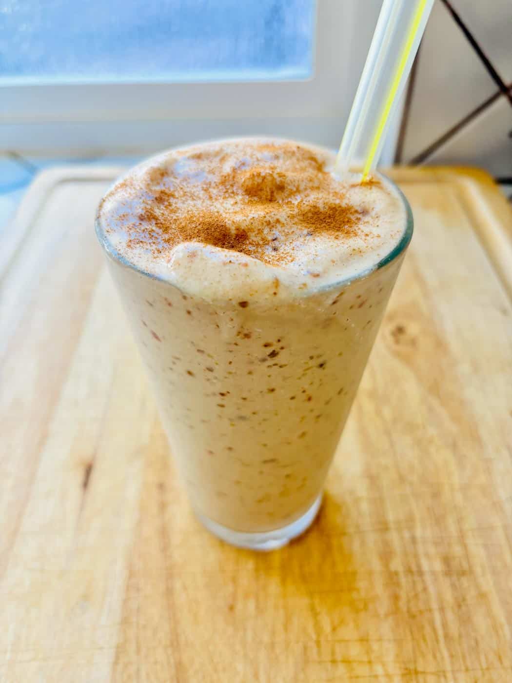 Date shake in a glass with a straw.
