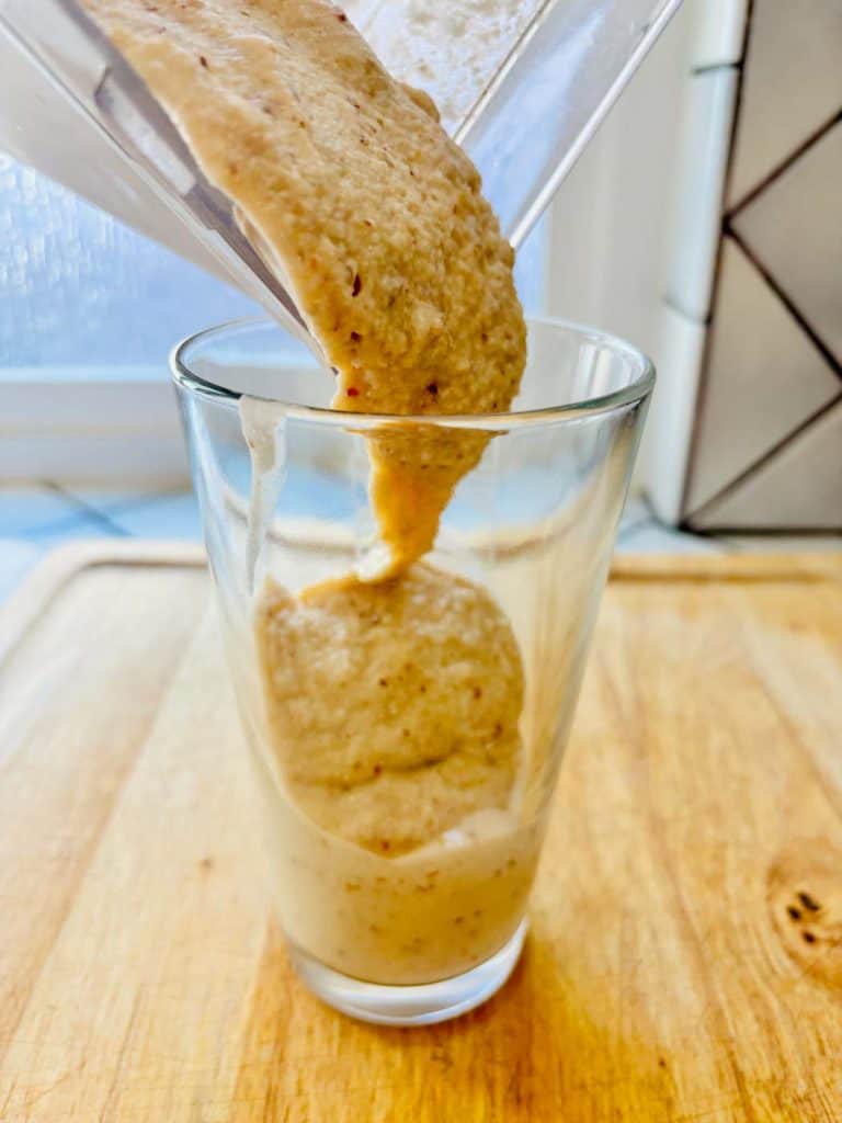 Date shake being poured into a glass.
