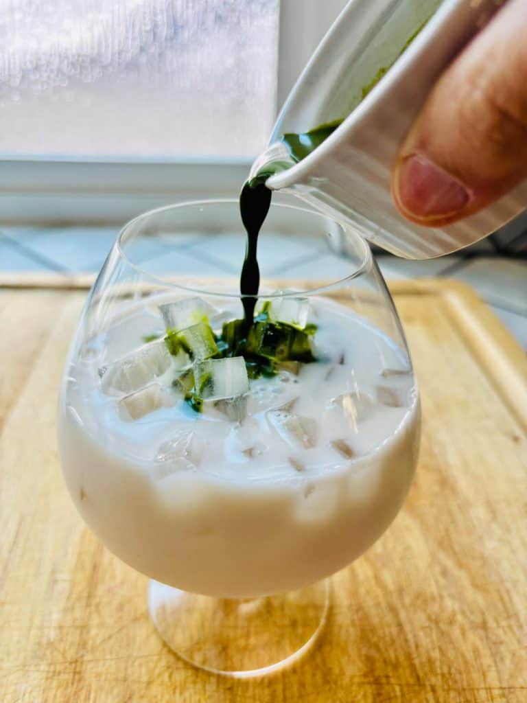 Matcha poured into a glass of ice and milk.