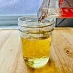 Simple syrup being poured into a jar.