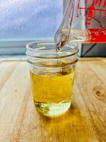 Simple syrup being poured into a jar.