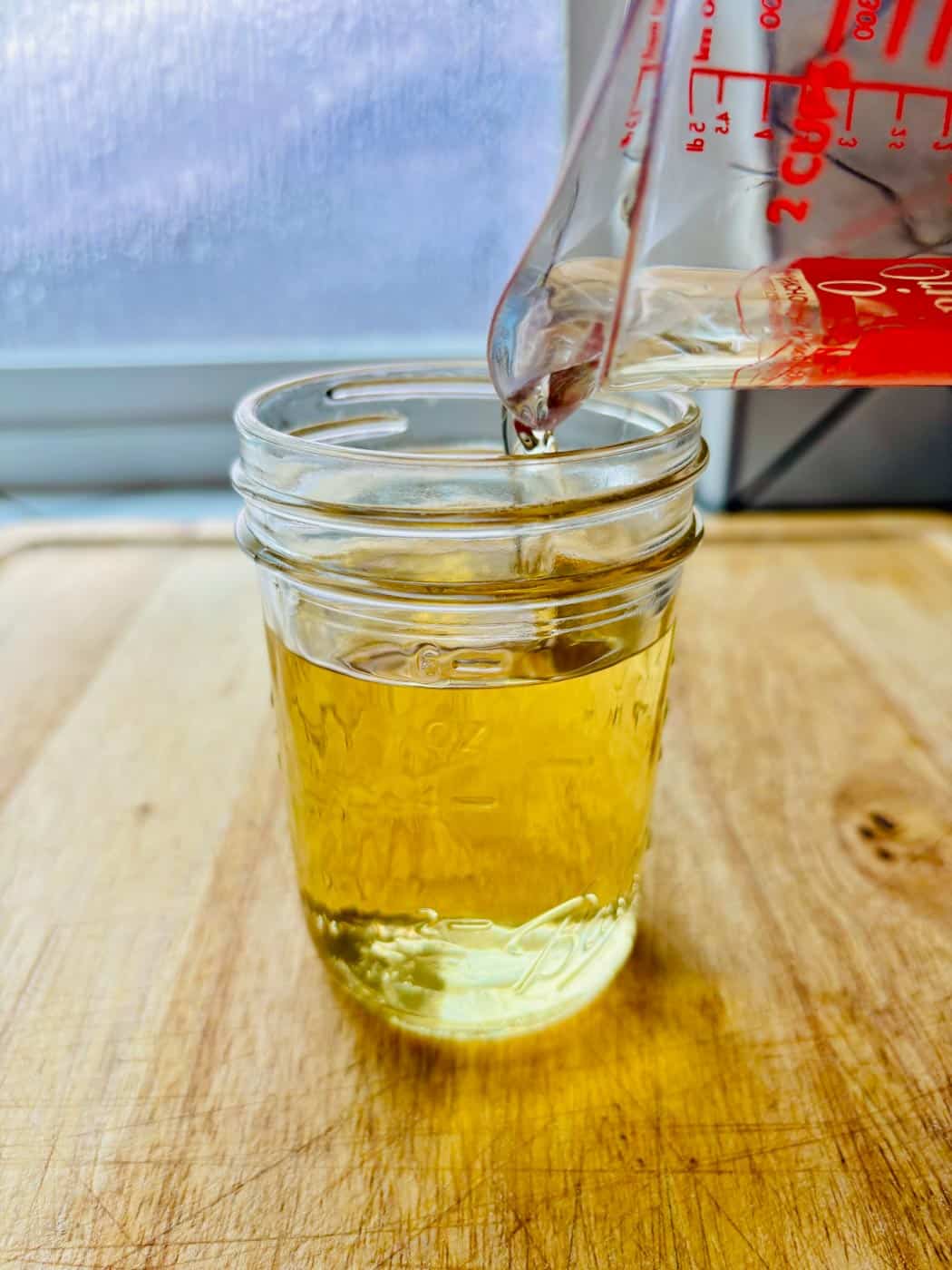 Simple syrup being poured into a jar.