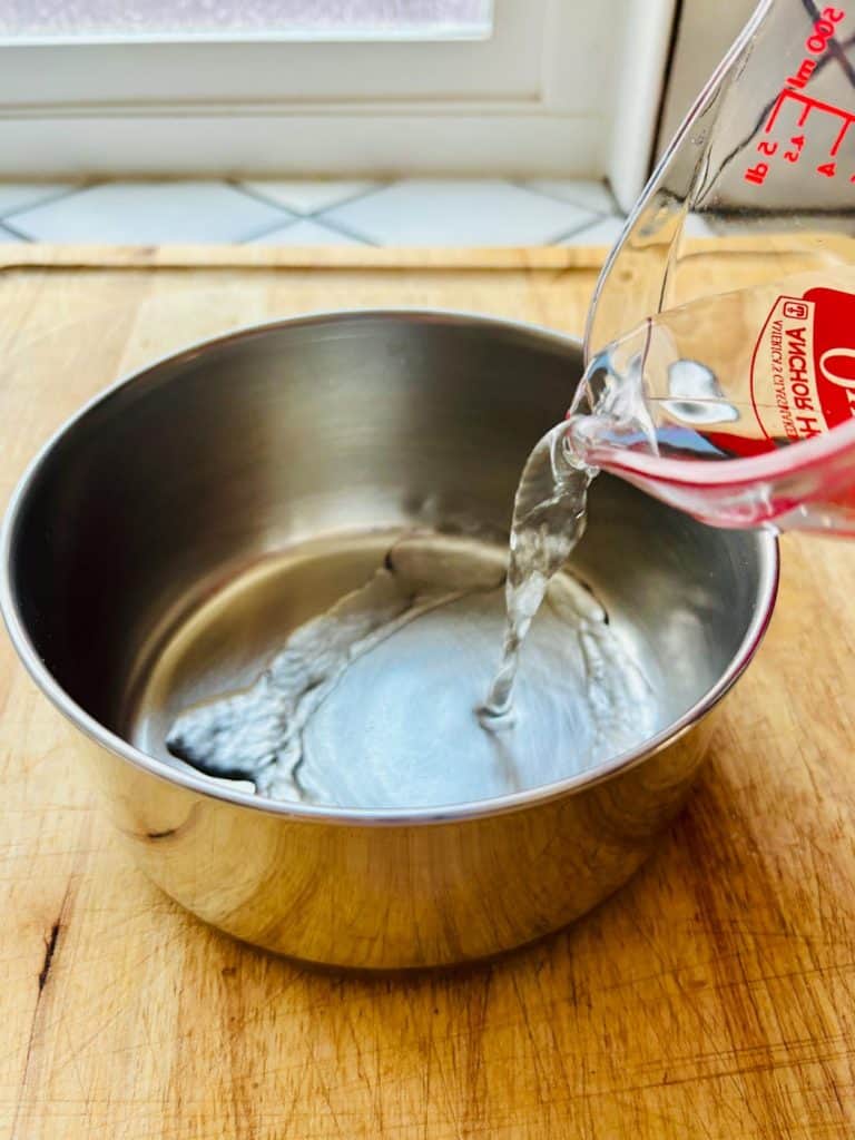 Pouring water into a saucepan.