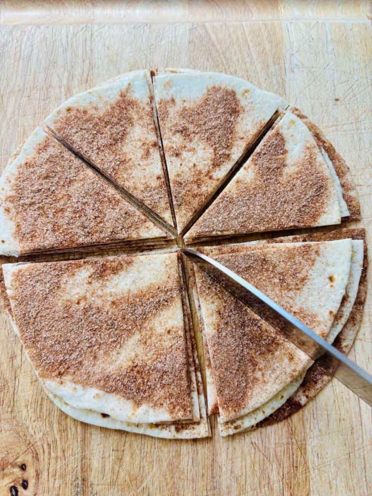 Cutting tortillas into triangles.