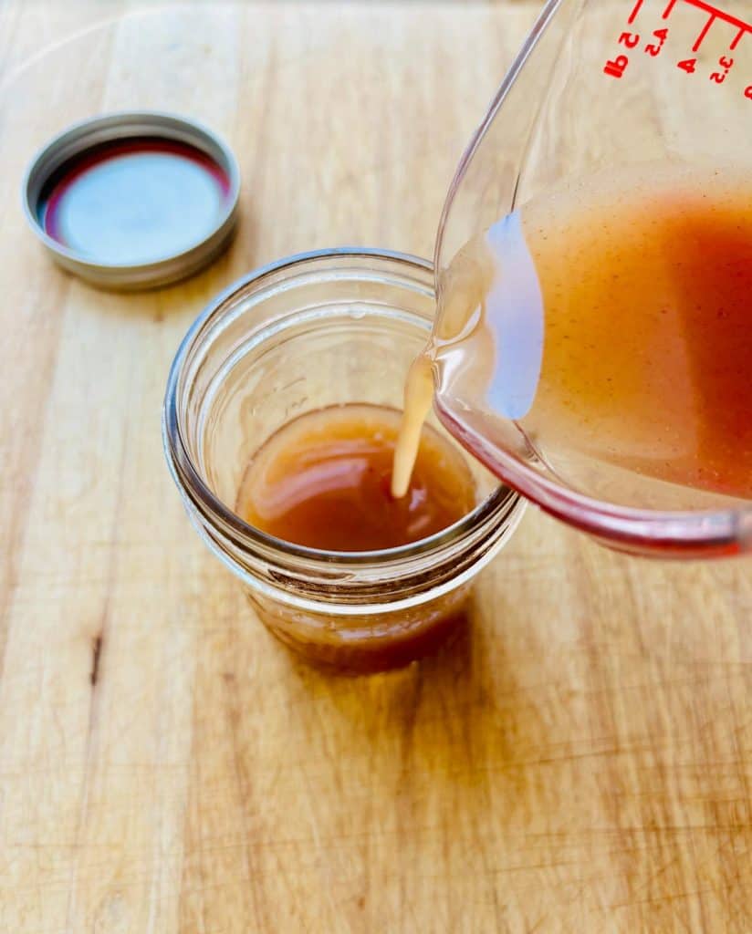 Pouring the syrup into a mason jar.