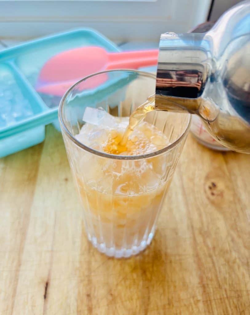Adding tea to the glass.
