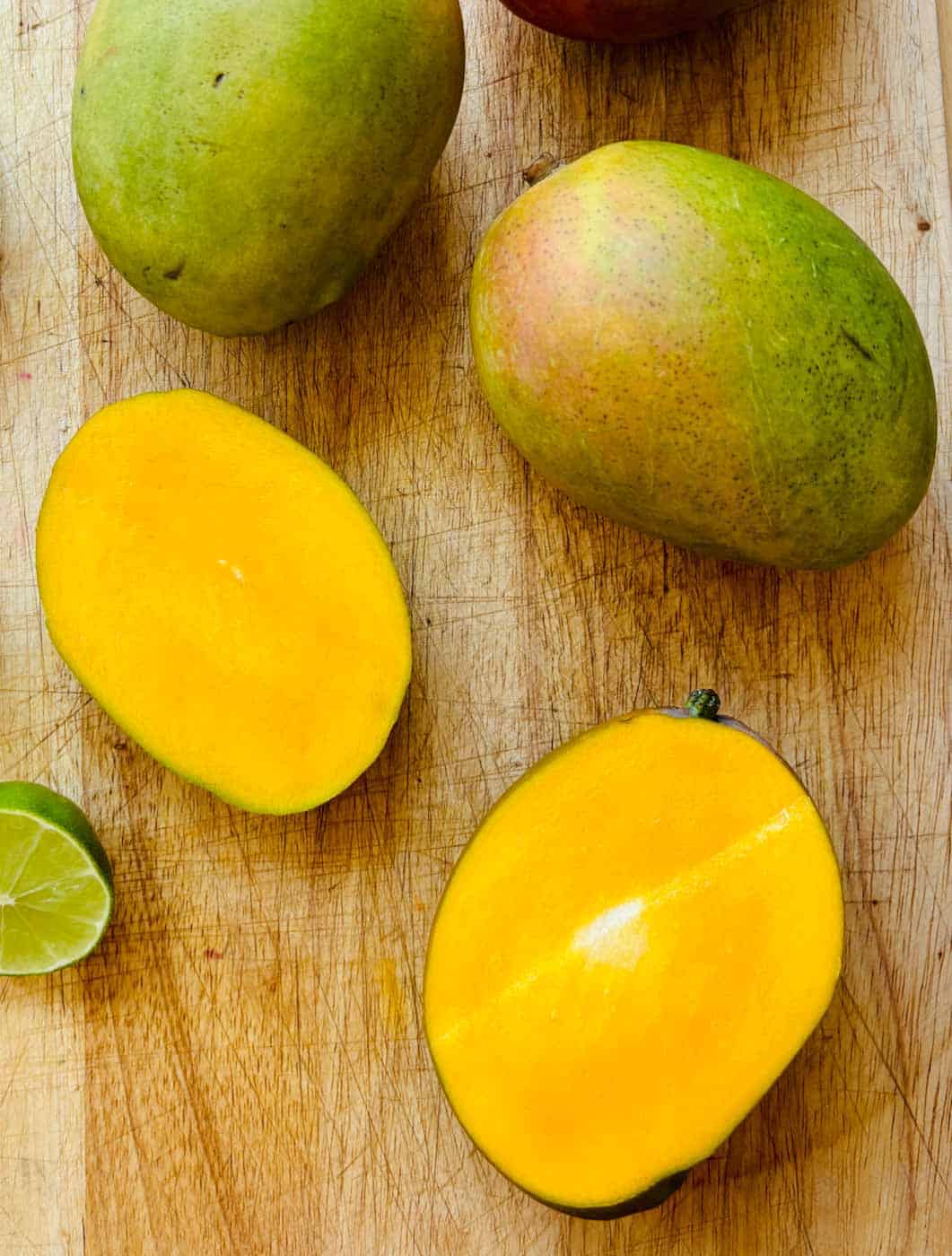 Mangoes, whole and cut in half.