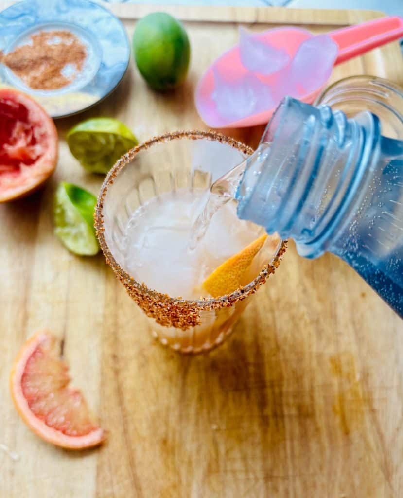 Pouring in the sparkling water.
