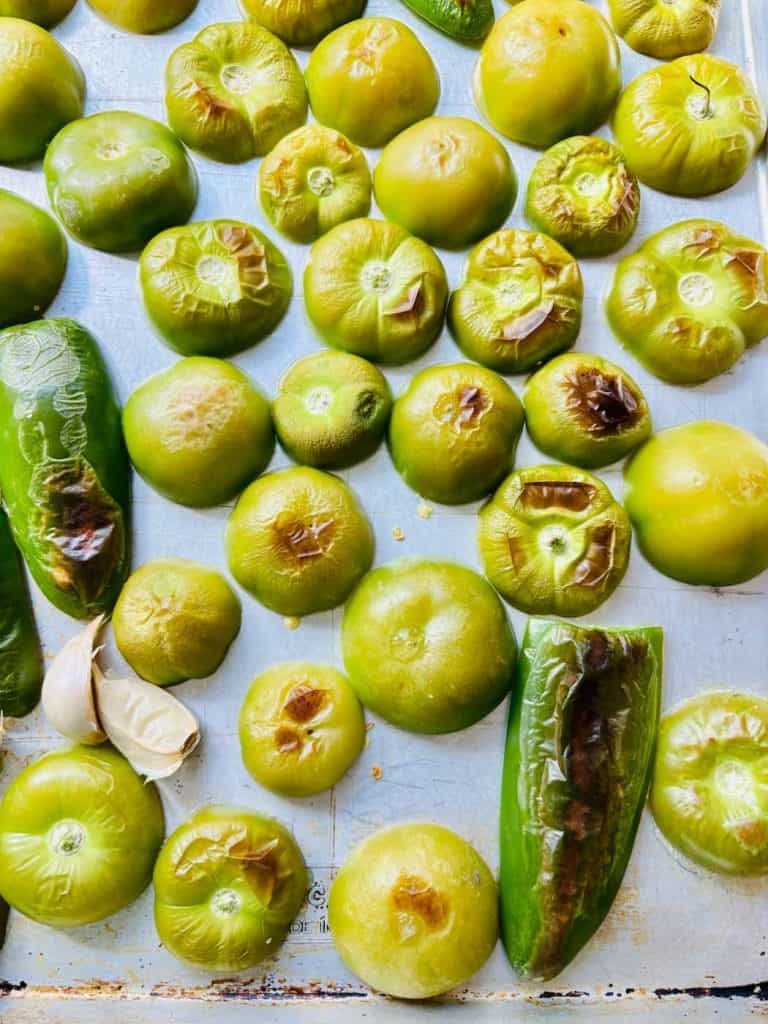 Cut tomatillos and jalapeno on a sheet pan.